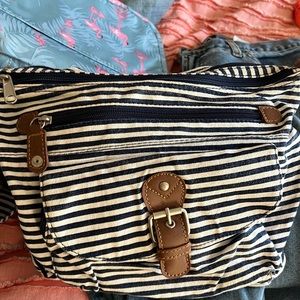 Bag is roomy with 2 compartments zippered & pouch in front with leather accents